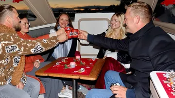 Group toasting on a boat during sunset.