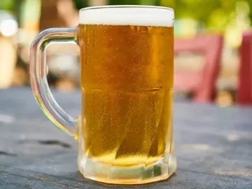 Ein Bierkrug steht auf einem Tisch im Freien.
