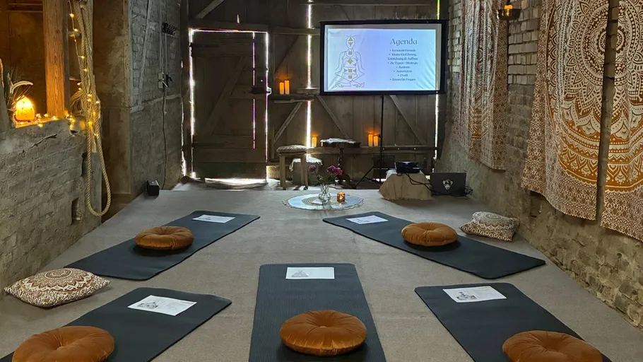 Meditation space with mats and cushions, rustic room.