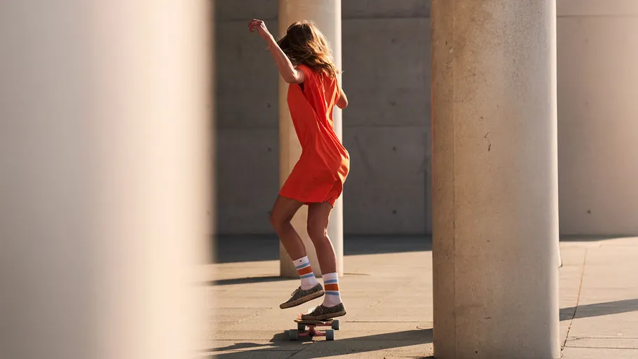 Woman skateboarding between concrete pillars.