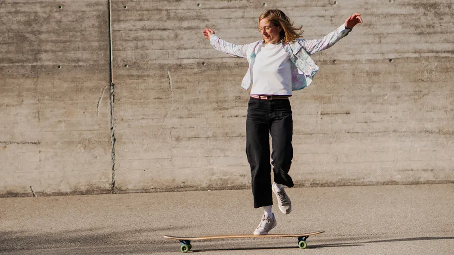 Woman skateboarding, jumping in urban area.