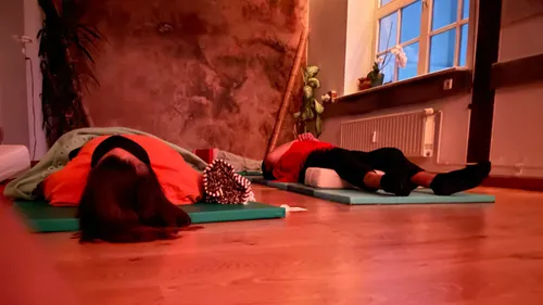 Two people lying on mats in a room.
