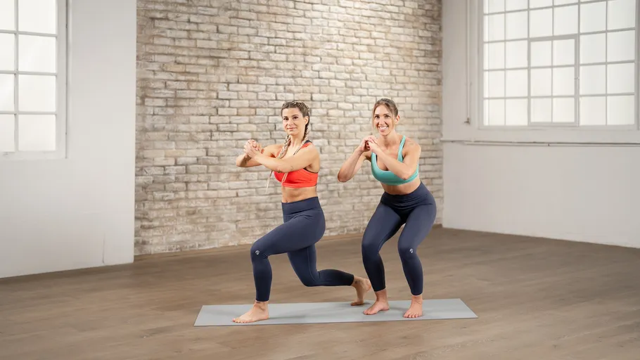 Two women doing lunges in a bright room.