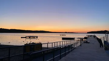 Sonnenuntergang über See mit Holzsteg.