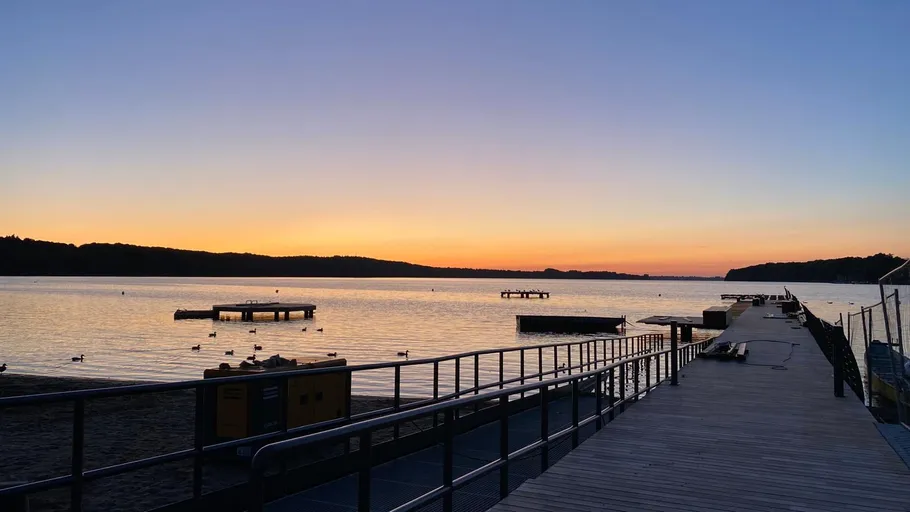 Sonnenuntergang über See mit Holzsteg.