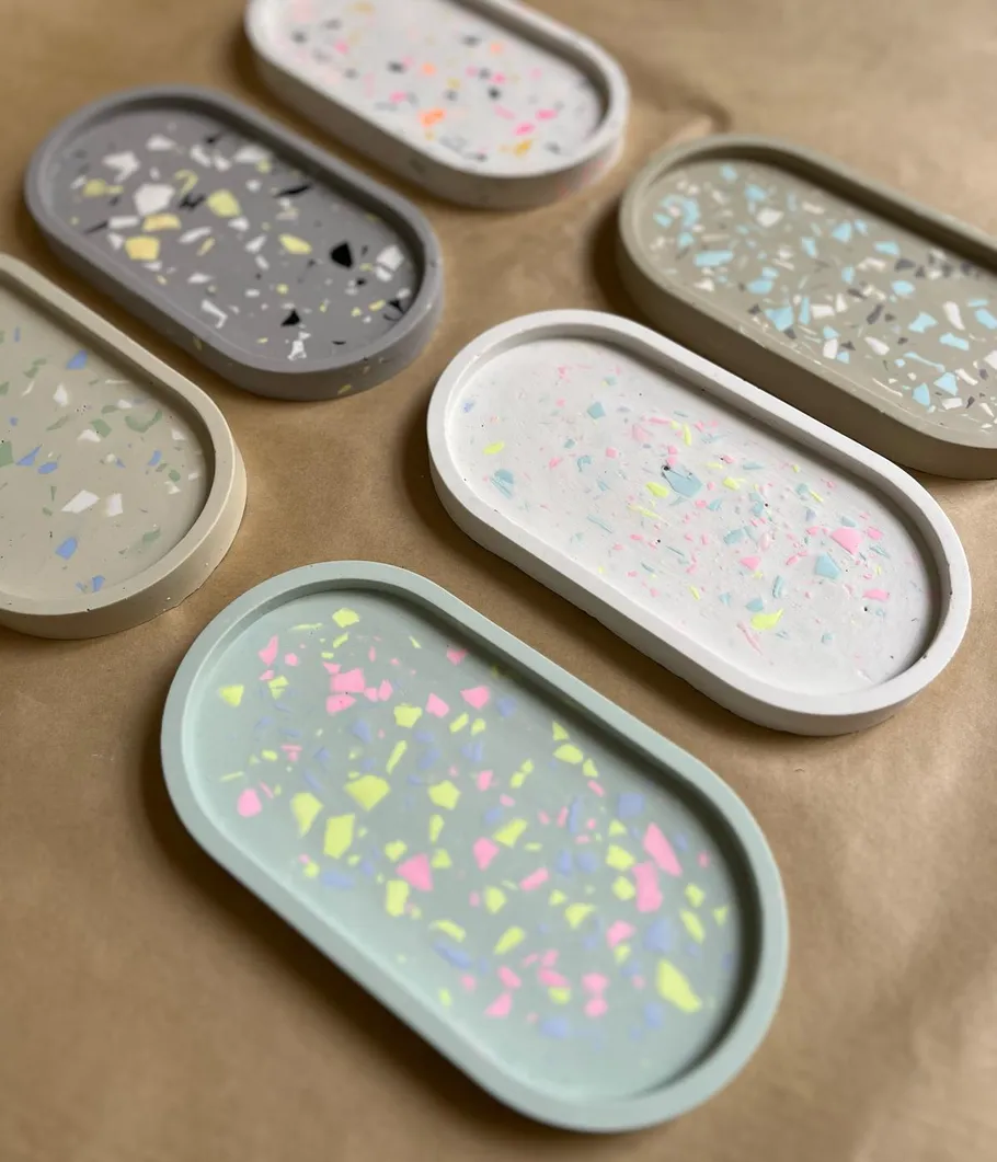Bunte Terrazzo-Tabletts auf brauner Oberfläche.