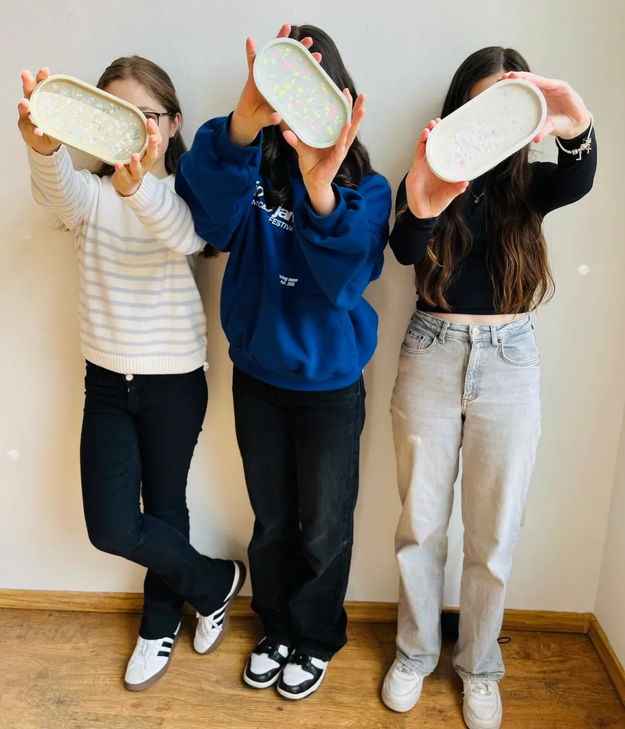 Three people holding trays, white background.