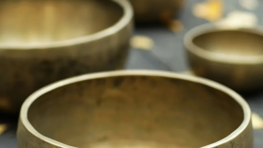 Close-up of metal singing bowls, blurred background.