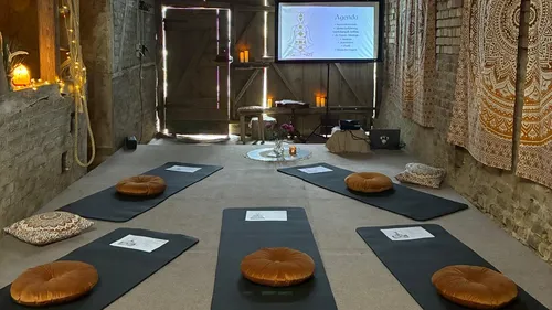 Yoga-Matten und Kissen in rustikalem Raum.