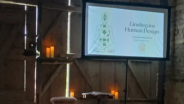 Präsentation in schummrig beleuchtetem rustikalem Raum.