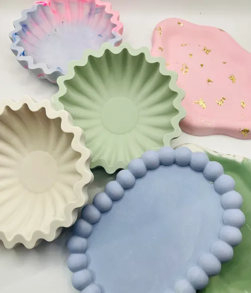 Bunte dekorative Tabletts auf weißer Oberfläche.
