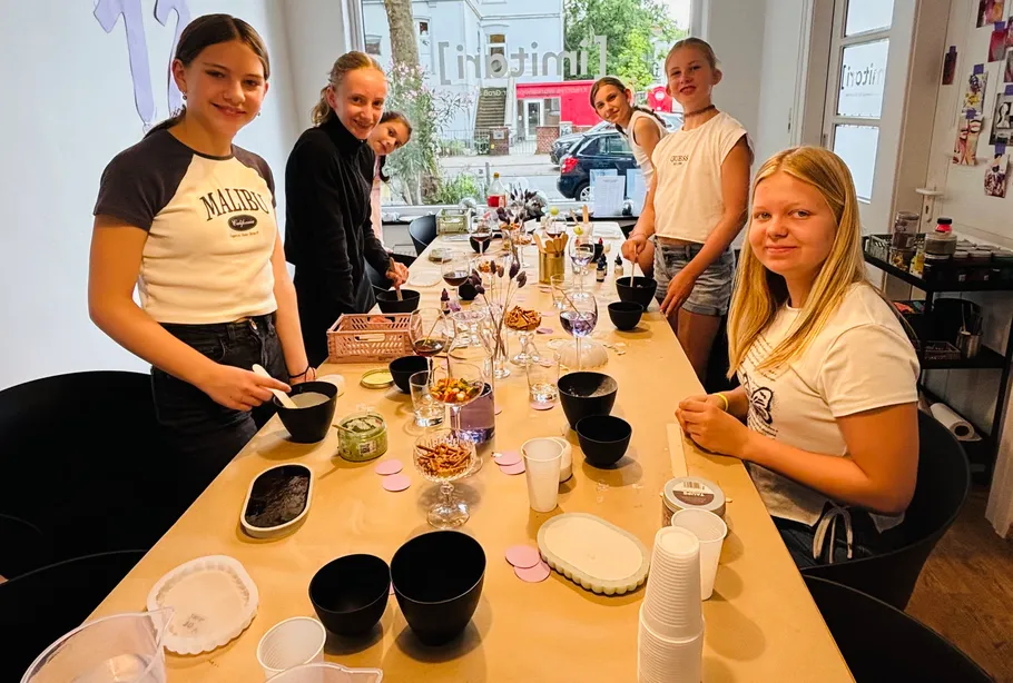 Mädchengruppe bastelt drinnen.