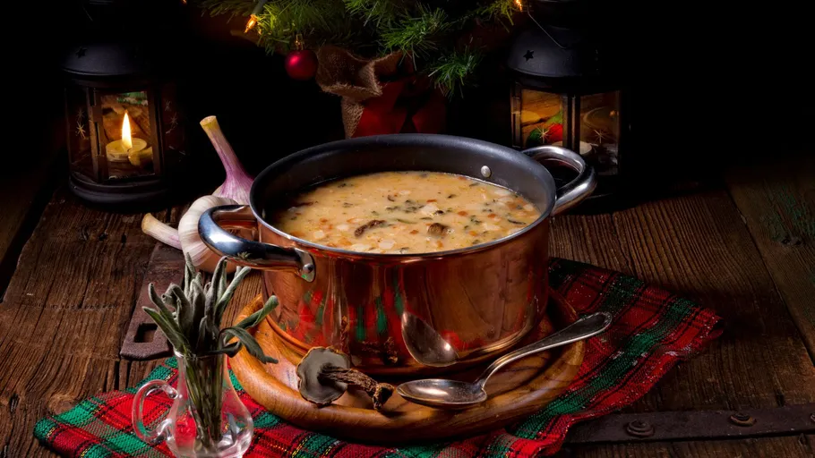 Soup in pot on wooden table, festive decor.