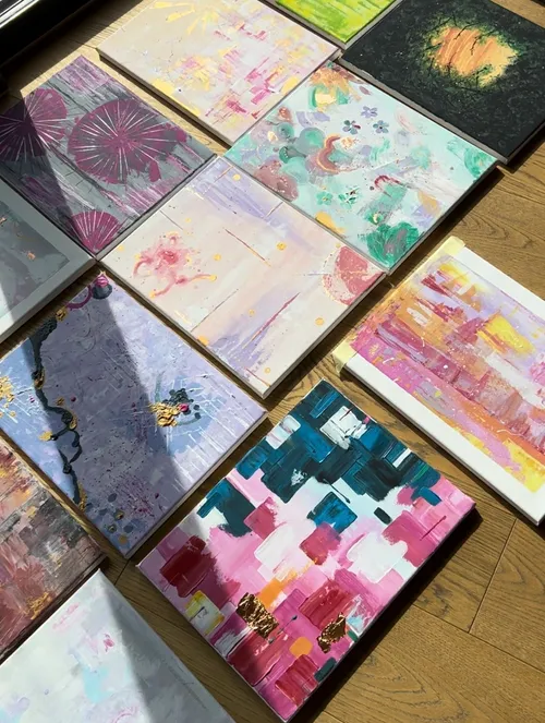 Abstract paintings arranged on wooden floor.