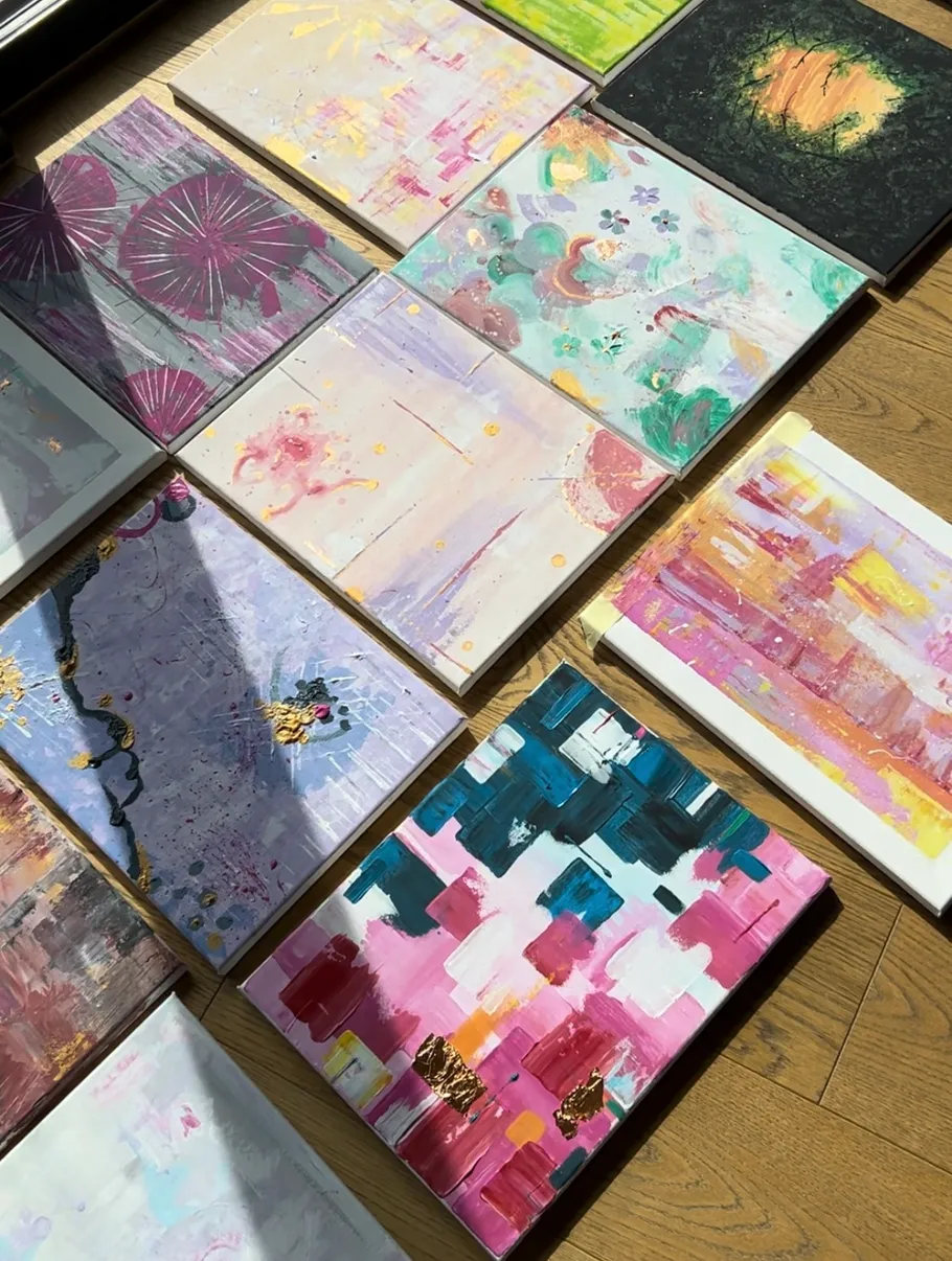 Abstract paintings arranged on wooden floor.