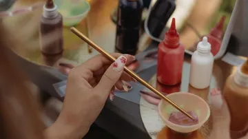 Hand painting with brush on palette.