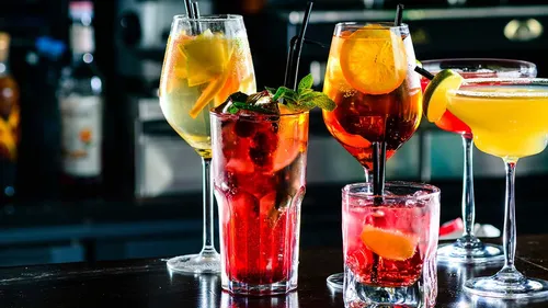 Various colorful cocktails on a bar counter.