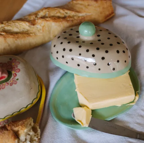 Butterdose mit Brot auf Stoffoberfläche.