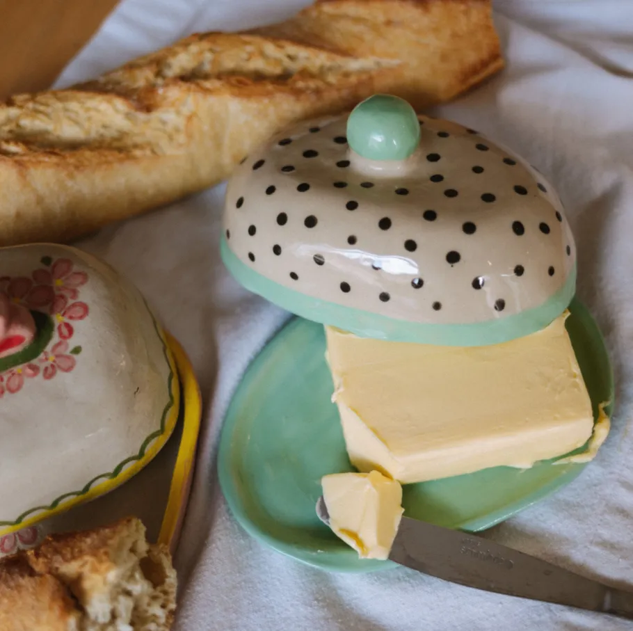 Butterdose mit Brot auf Stoffoberfläche.