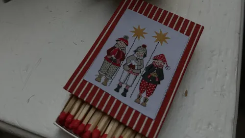 Festliche Streichholzschachtel mit drei illustrierten Kindern.