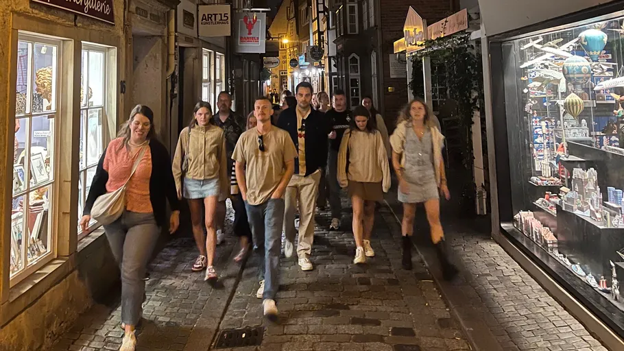 Group walking in cobblestone street, night shopping.