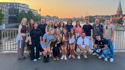 Gruppe von Menschen posiert auf einer Brücke.