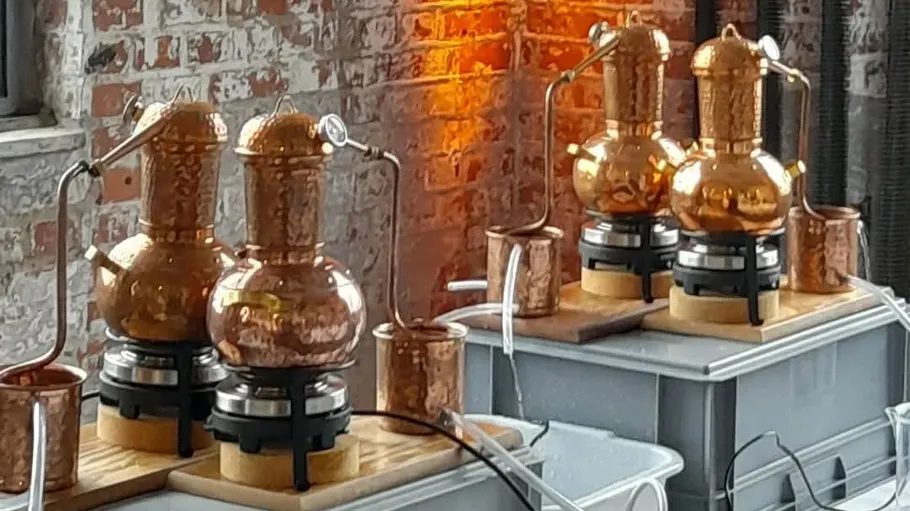 Copper stills on plastic containers, brick background.