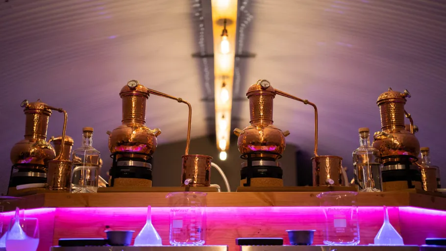 Copper distillery equipment in a dimly lit room.