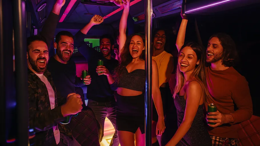Group dancing and smiling on a party bus.