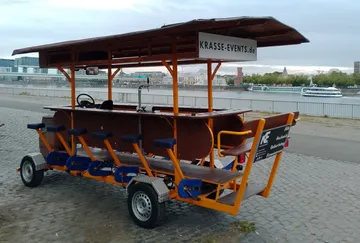 Tretbetriebener Barwagen am Ufer.