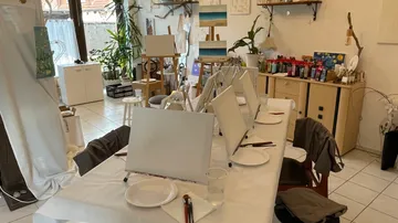 Kunststudio mit Leinwänden auf Tischen.