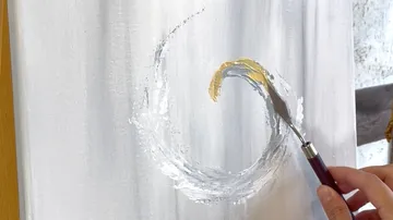 Hand painting golden crescent on white canvas.