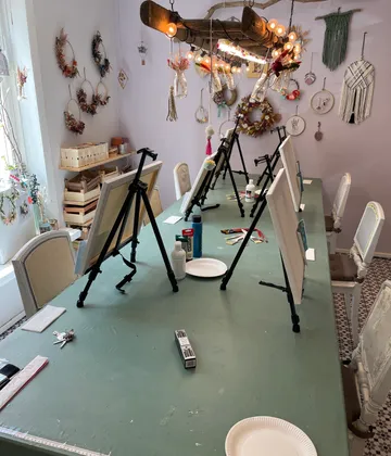 Kunststudio mit Staffeleien auf einem Tisch.