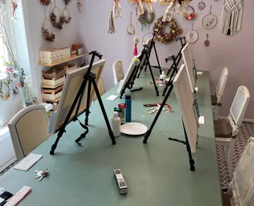 Kunststudio mit Staffeleien auf einem Tisch.