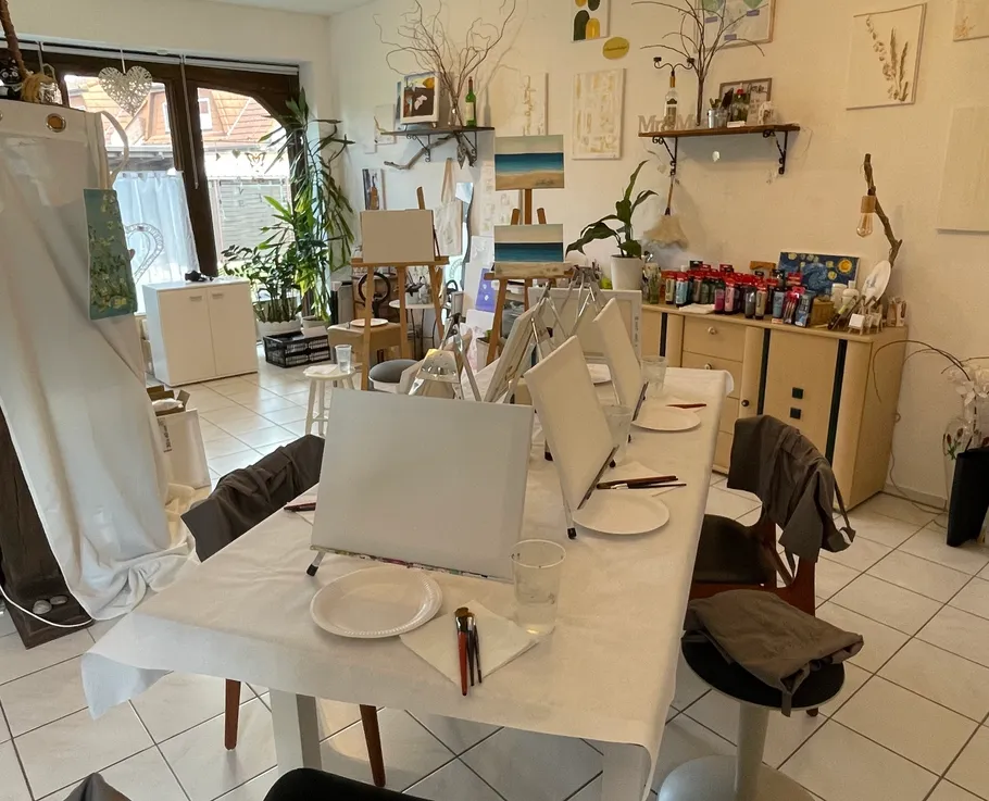 Art studio with easels and supplies on tables.