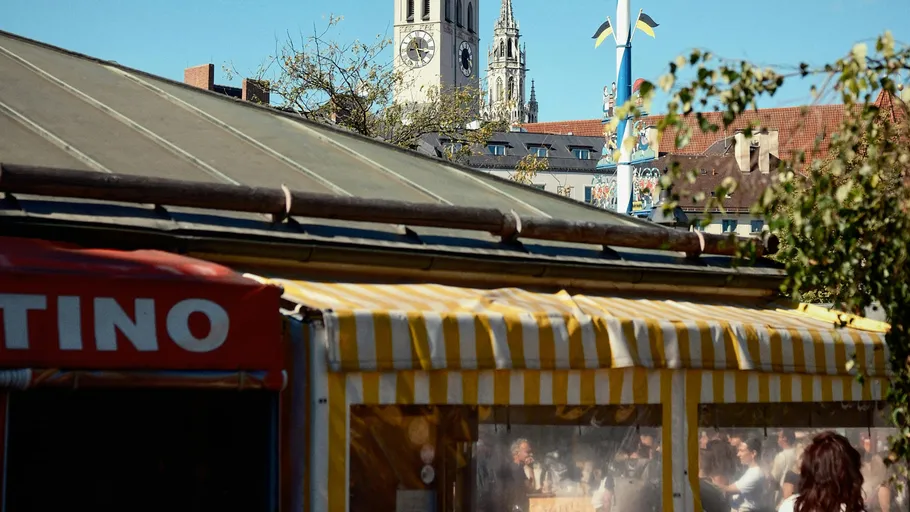Marktstände mit Uhrturm im Hintergrund.