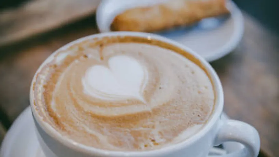 Latte with heart art in coffee shop.