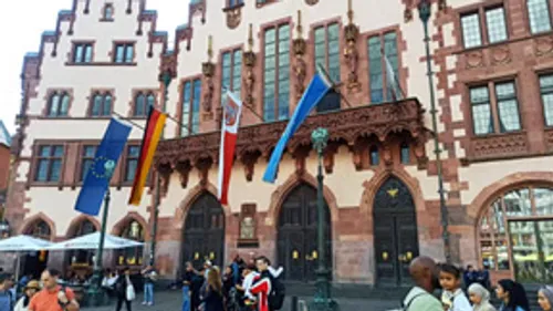 Bunte Fahnen vor historischem deutschen Gebäude.