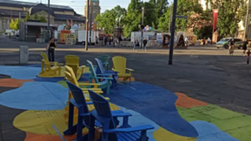 Colorful chairs on painted street, outdoor setting.