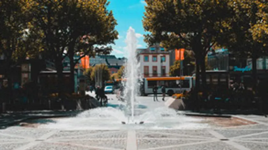 Brunnen sprüht Wasser auf Stadtplatz.