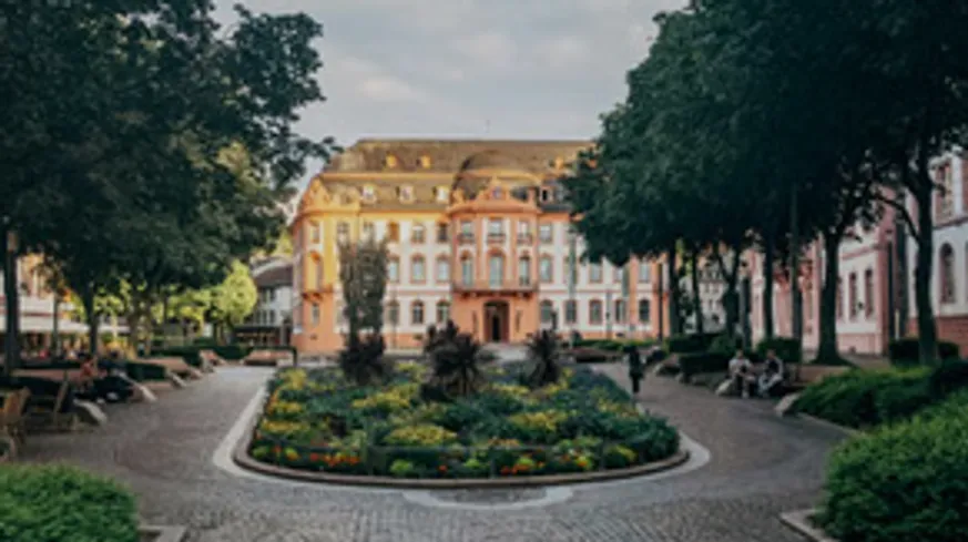 Prunkvolles rosa Gebäude hinter Gartenweg.
