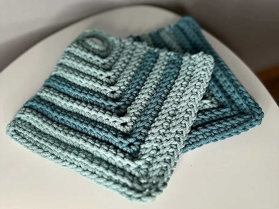 Gehäkelte Topflappen auf weißer Oberfläche.