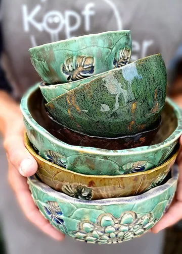 Hand holding stack of ceramic bowls.