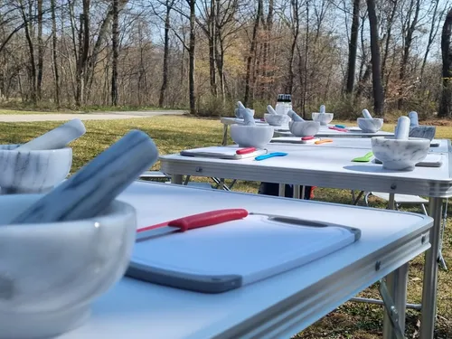 Mortars and pestles are placed on outdoor tables.