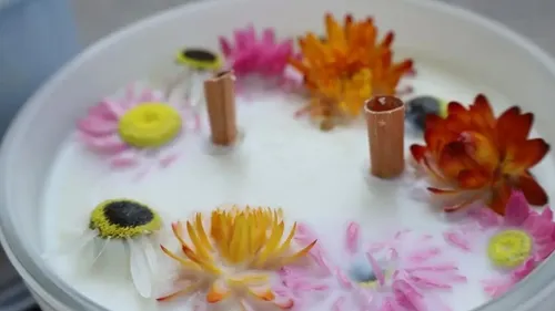 Dekorative Kerze mit bunten Blumen gezeigt.