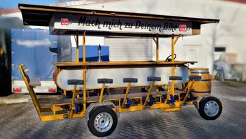 Pedal bar cart parked on pavement.