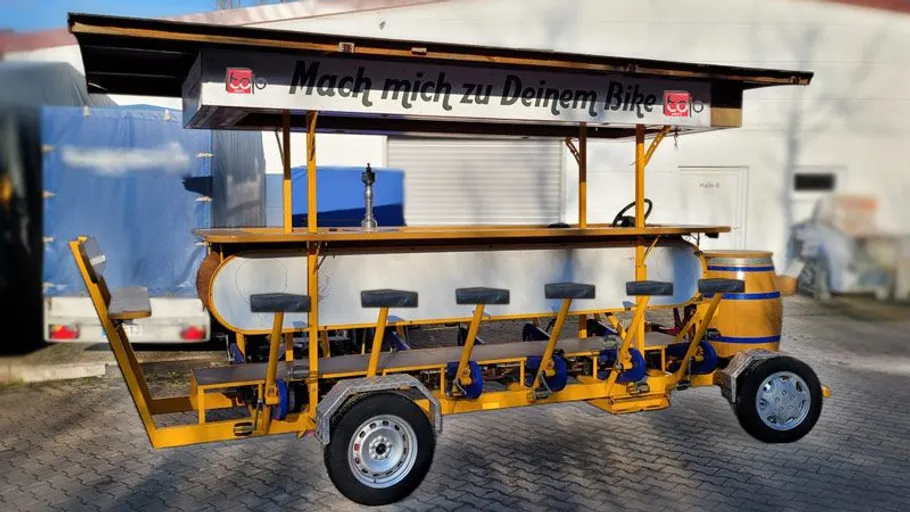 Pedal bar cart parked on pavement.