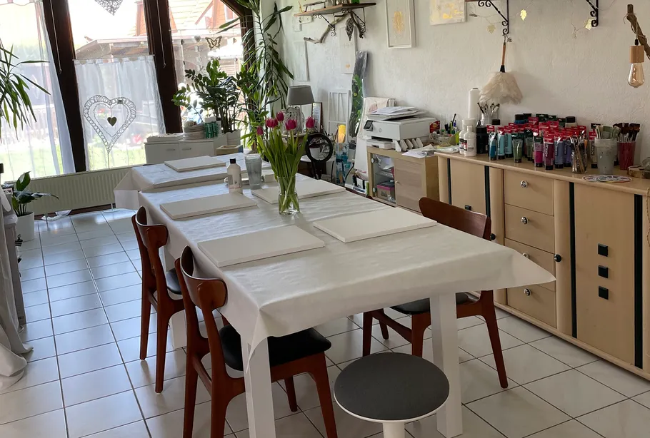 Esstisch zum Malen mit Materialien gedeckt.