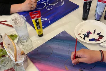 People painting on canvases with acrylics.
