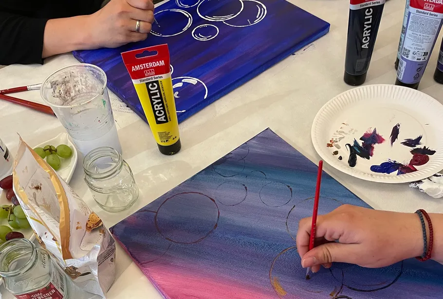 Personen malen auf Leinwänden mit Acrylfarben.